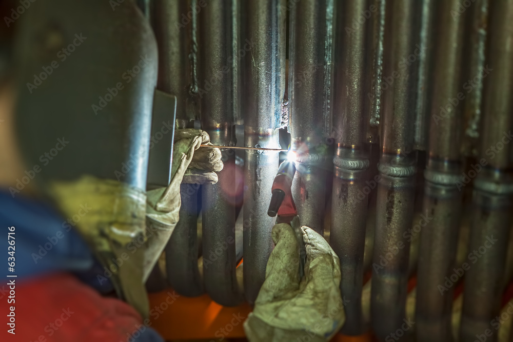 Naklejka premium Welder welding metal pipes