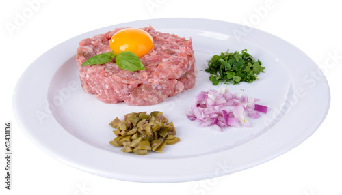 Delicious steak tartare with yolk on plate isolated on white