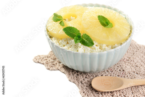 Bowl of tasty cottage cheese with pineapple, isolated on white photo