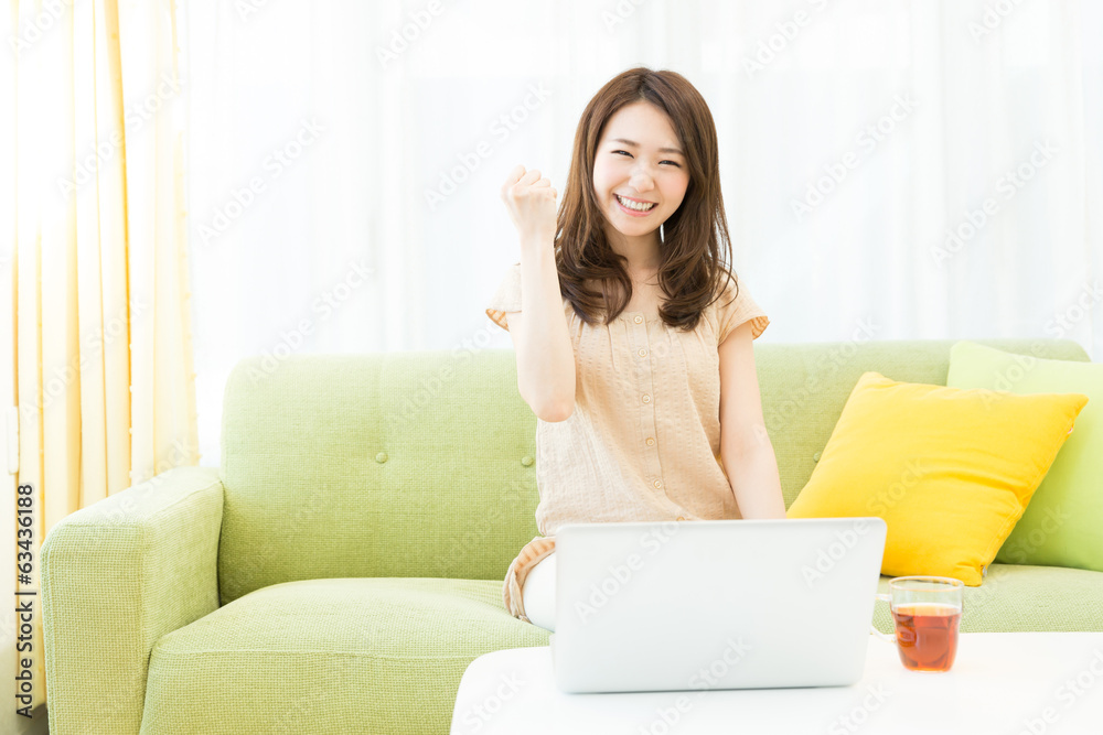 部屋でパソコンを使う女性 部屋でパソコンを使う女性