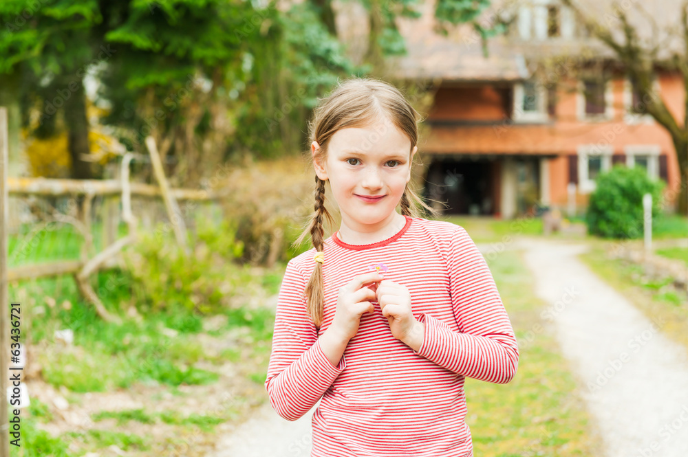 Adorable little girl standing against beautiful house Adorable little girl standing against beautiful house