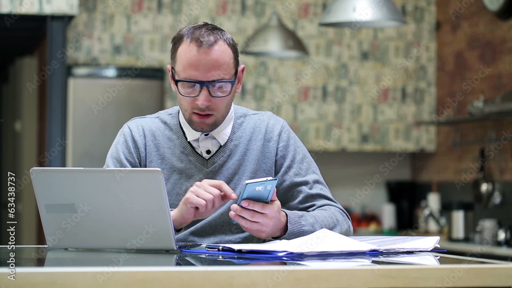 Businessman working on laptop and cellphone at home Businessman working on laptop and cellphone at home