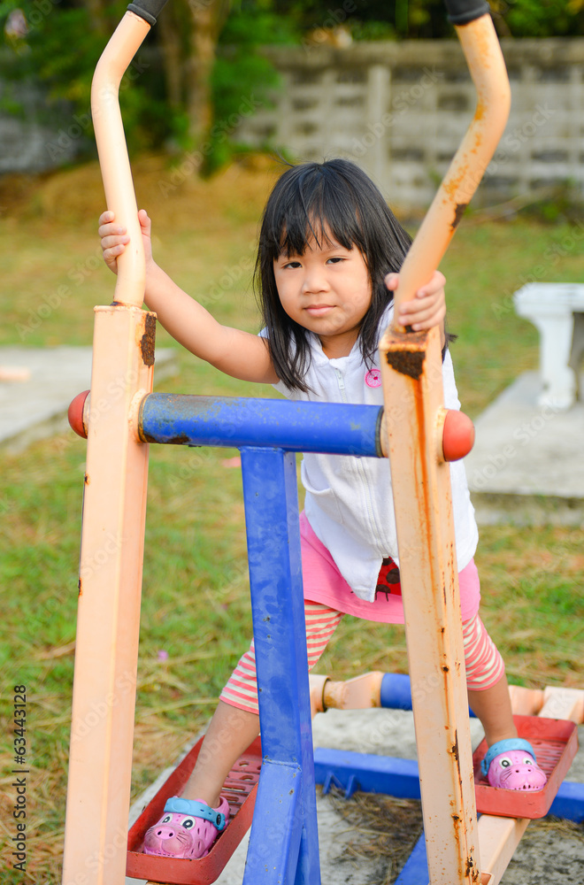 Obraz premium Cute litter girl exercise at playground