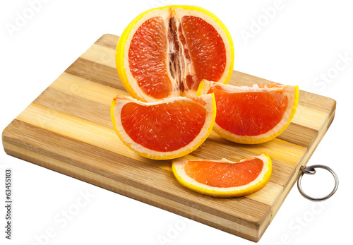 Red grapefruit slices on a wooden board