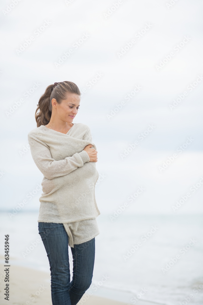 Young woman walking on cold beach Young woman walking on cold beach