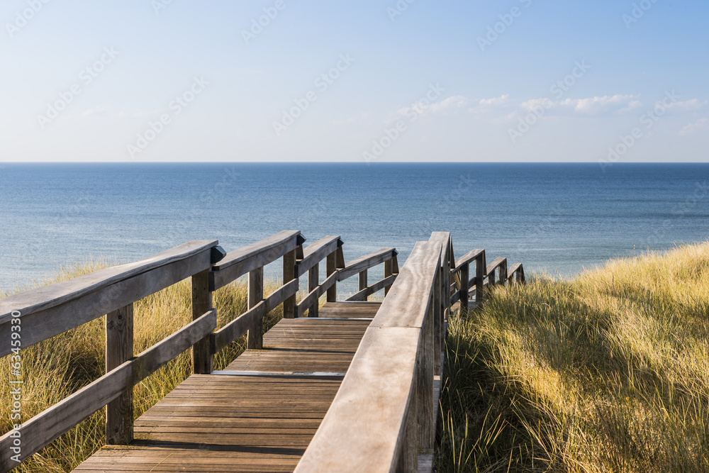 Wooden footpath through dunes at the North sea beach in Germany.