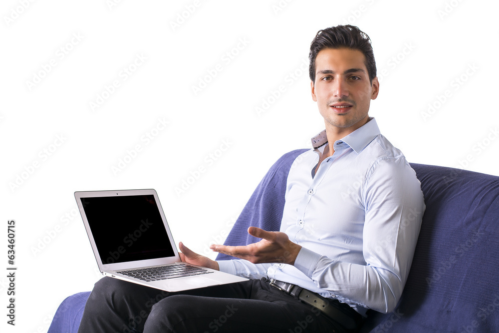 Young man showing laptop computer sitting on couch. Young man showing laptop computer sitting on couch.