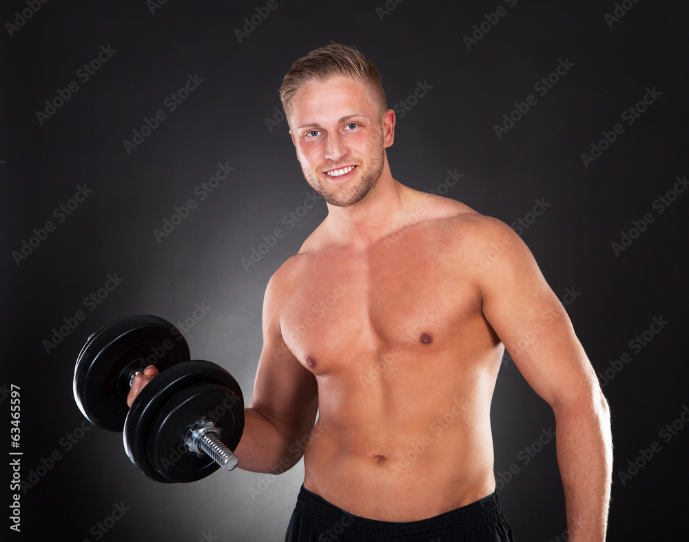 Young man working out lifting weights in a gym