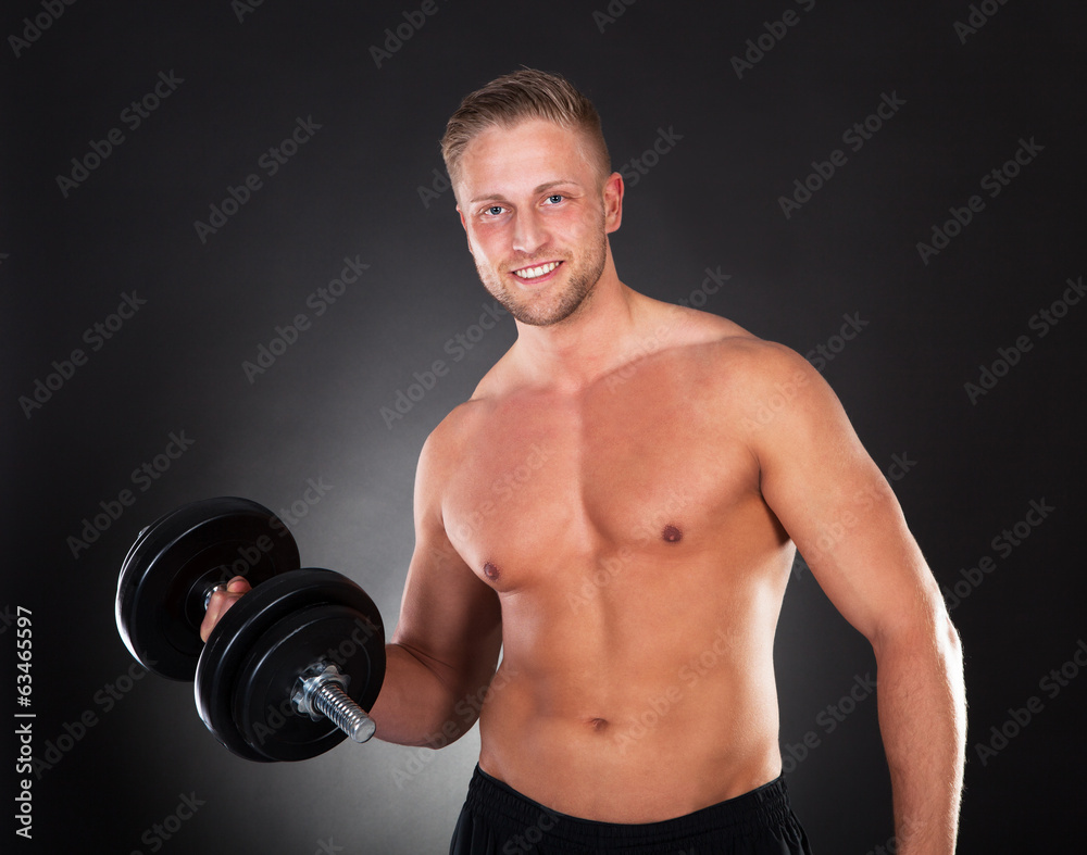 Young man working out lifting weights in a gym Young man working out lifting weights in a gym
