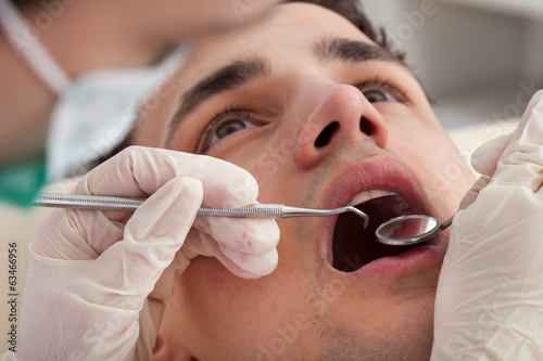 Cropped Image Of Dentist Examining Patient's Mouth