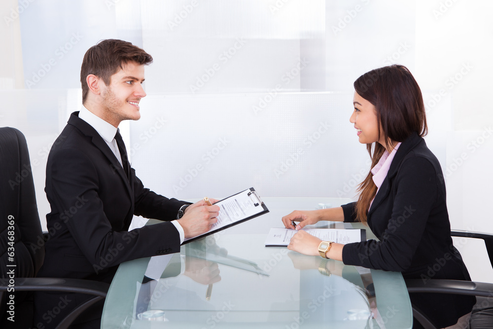 Business Colleagues Discussing At Desk Business Colleagues Discussing At Desk