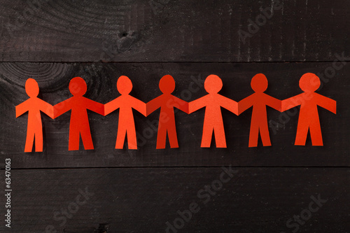 Team of paper doll people holding hands photo