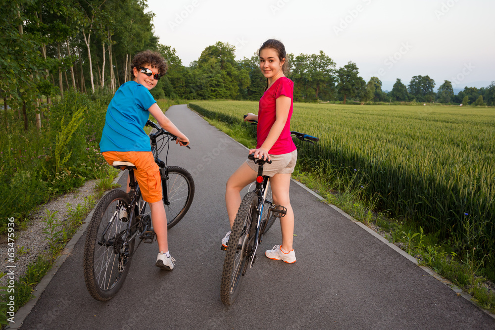 Healthy lifestyle - teenage girl and boy biking Healthy lifestyle - teenage girl and boy biking