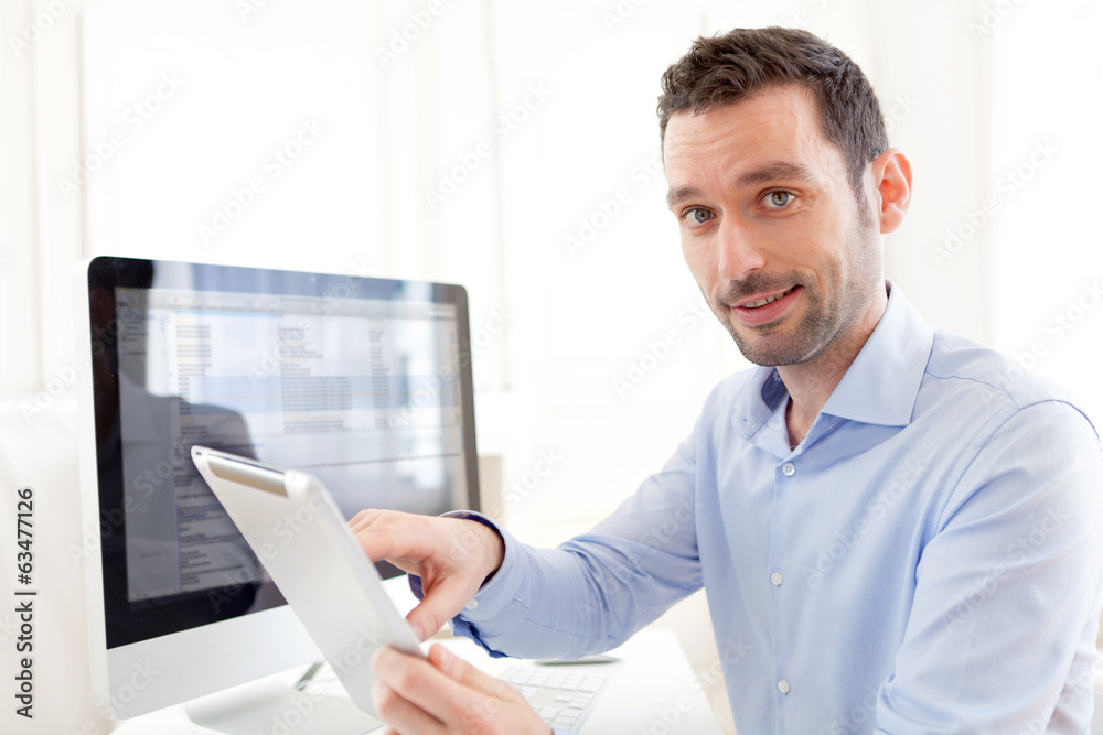 Young business man working at home on his tablet