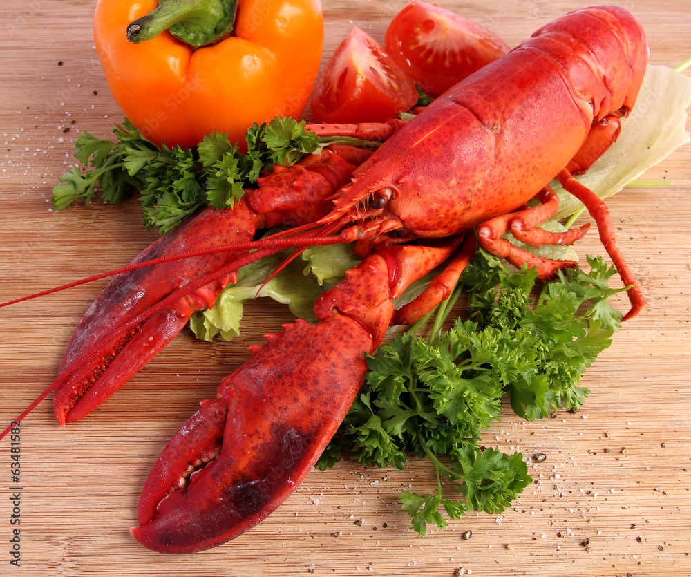 Cooked lobster with various vegetables on wooden board Cooked lobster with various vegetables on wooden board
