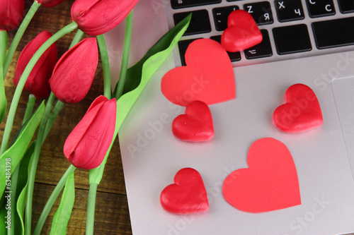Fototapeta Naklejka Na Ścianę i Meble -  Red hearts and flowers on computer keyboard close up