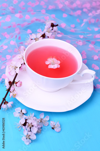 Fragrant tea with flowering branches on wooden table close-up