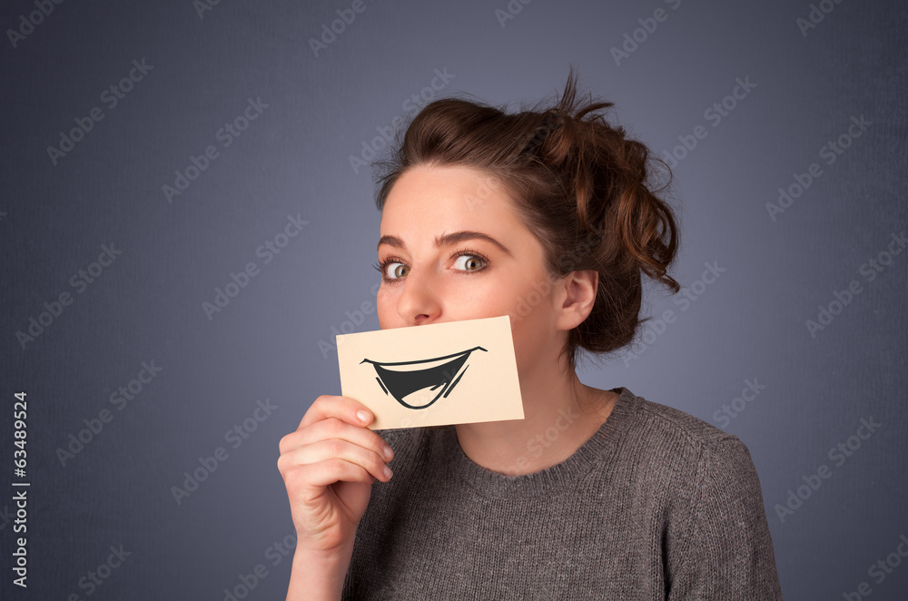 Happy cute girl holding paper with funny smiley drawing Happy cute girl holding paper with funny smiley drawing