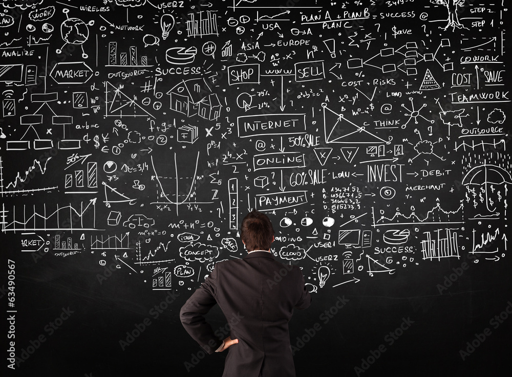 Businessman standing in front of drawn charts on a blackboard Businessman standing in front of drawn charts on a blackboard