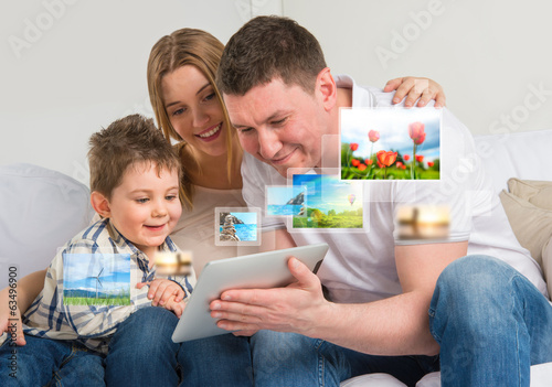Young happy family watching their photo and video files using mo