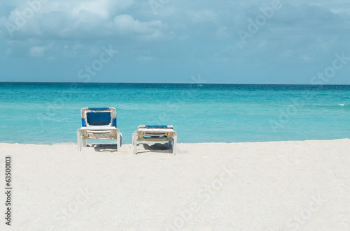 Fototapeta Naklejka Na Ścianę i Meble -  Romantic view of the Caribbean beach, two beach chairs