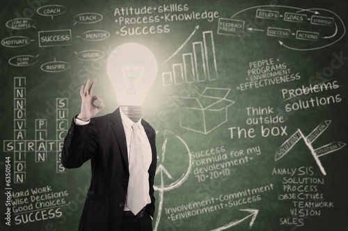 Businessman with lightbulb head in classroom