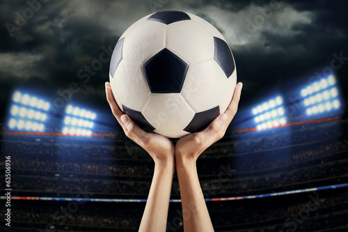 Hands holding soccer ball at stadium 1 © Creativa Images