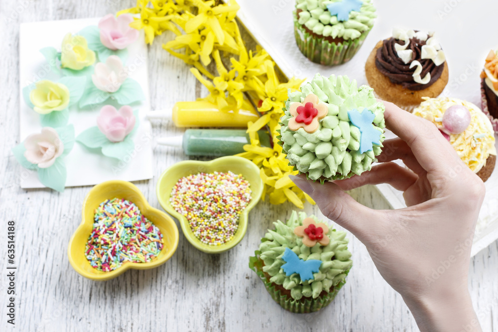 Woman decorates easter cupcakes