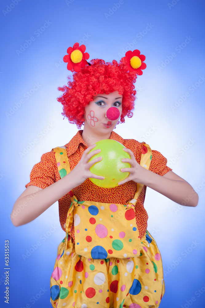 Clown woman with a ball on blue background Clown woman with a ball on blue background