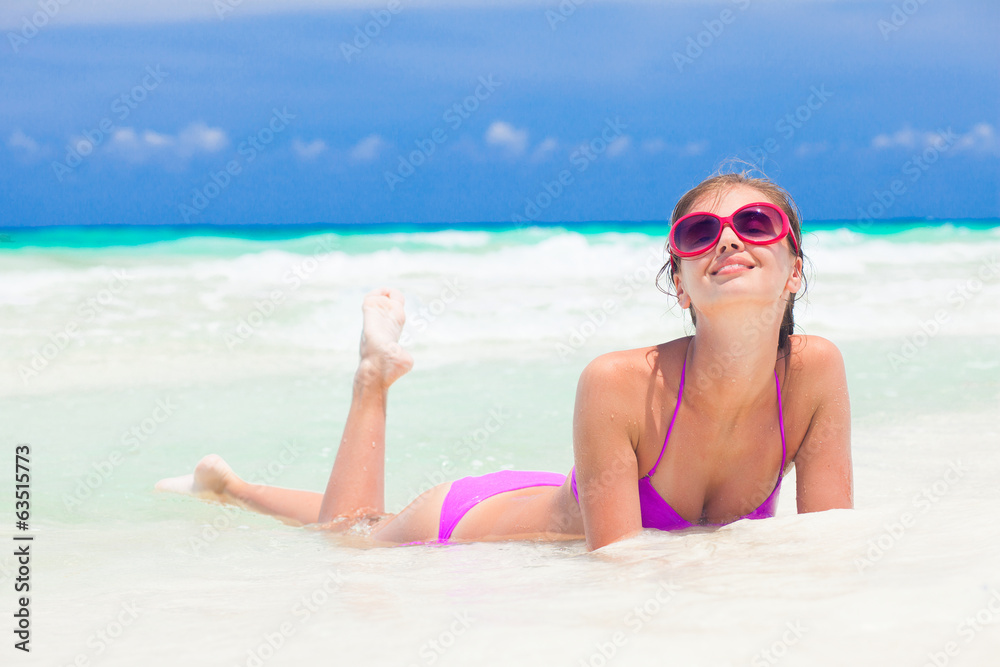long haired young woman in bikini and sunglasses in water on long haired young woman in bikini and sunglasses in water on
