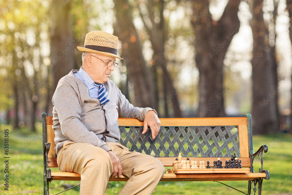 Fototapeta premium Lonley senior playing chess outdoors