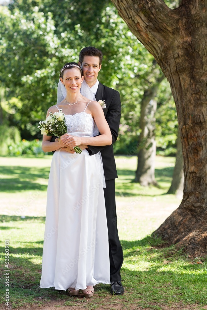 Groom and bride with flower bouquet in park Groom and bride with flower bouquet in park