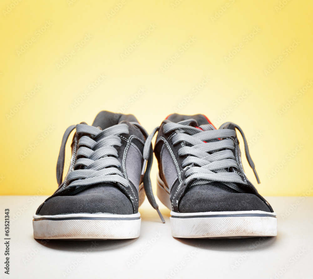 Pair of grey sneakers on colorful background