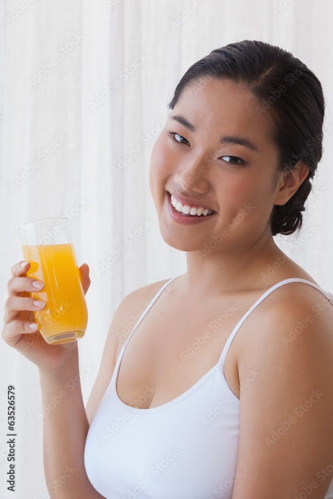 Pretty asian woman holding glass of orange juice Pretty asian woman holding glass of orange juice
