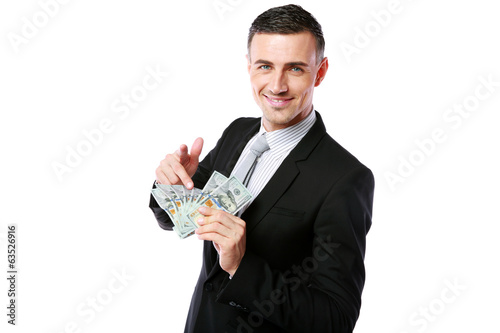 Smiling businessman holding US dollars and showing on you 