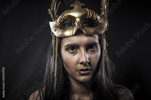 Clubbing sensual young woman with golden mask jewelry