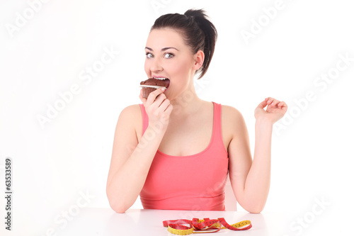 Joyful and young woman eating tasty chocolate cake