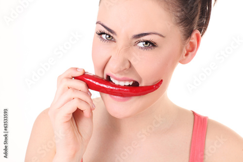 Beautiful woman with chili pepper in mouth