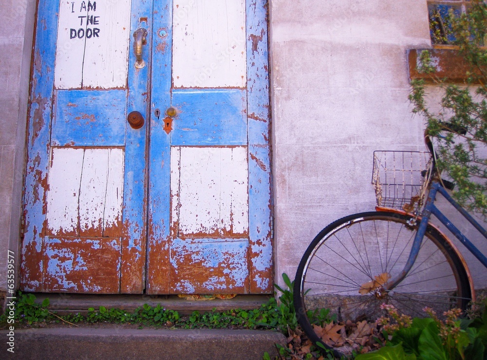 Old bicycle is parked near the door at an old house Old bicycle is parked near the door at an old house