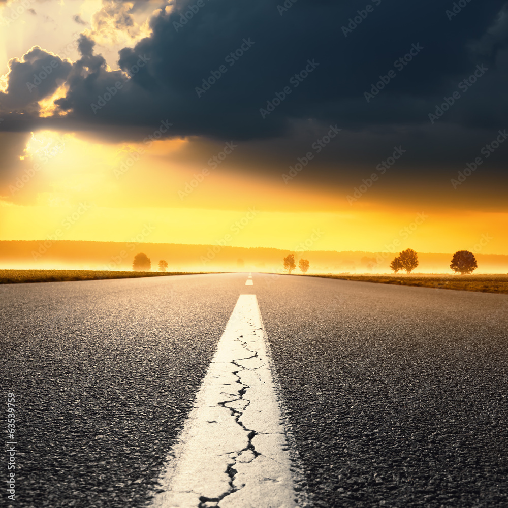Fototapeta premium Driving on an empty asphalt road at sunrise