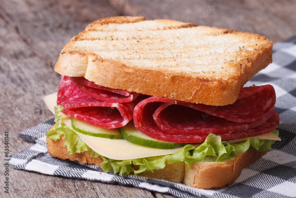 toast with salami, cheese and vegetables on an old table toast with salami, cheese and vegetables on an old table