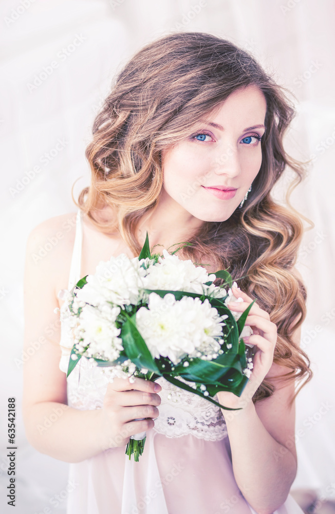 Beautiful girl lying on the white bed with flowers.