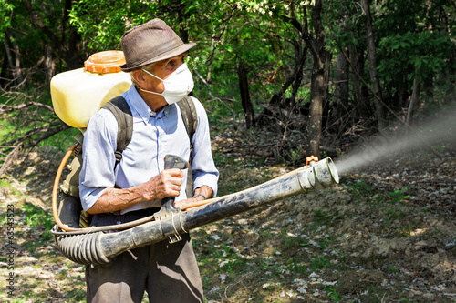 Obraz na płótnie Peasant spraying the trees with chemicals w salonie