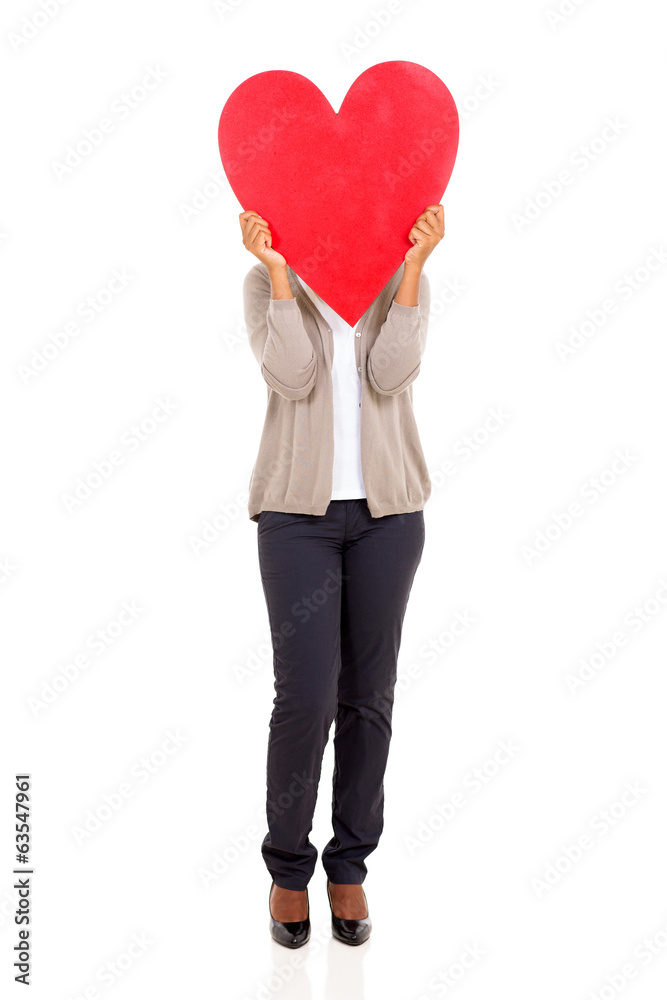 young woman hiding her face behind heart shape young woman hiding her face behind heart shape