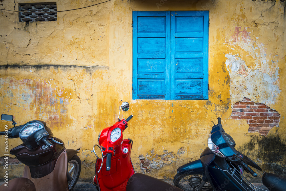 Naklejka premium Bikes parked near building with grungy wall.