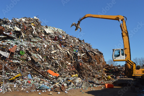Crane grabber snatch recycling metal at a scrap-iron junk