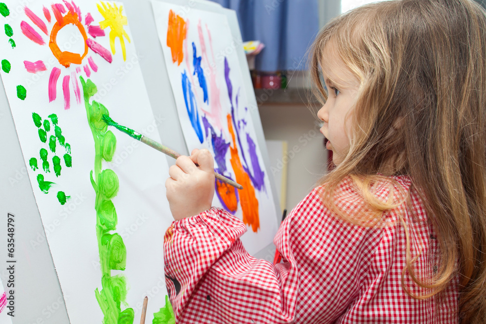 Little girl painting on paper