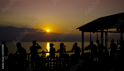 Unrecognizable people enjoy beautiful sunset and drinks. © artur ivlijev