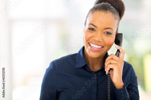 african businesswoman using landline phone photo