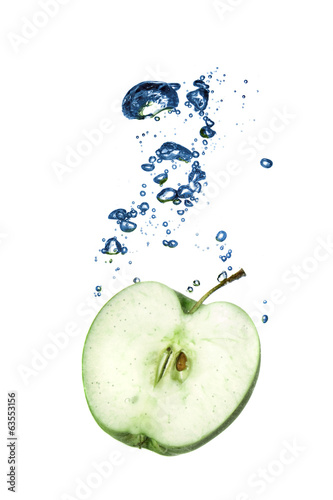 green apple dropped into water with bubbles isolated on white